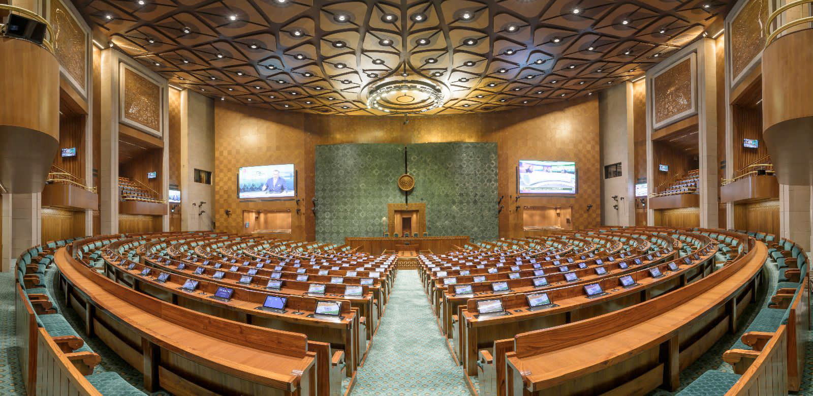 Rows of desks and seats facing the Speaker’s chair inside the empty Lok Sabha chamber.